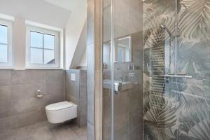 a bathroom with a toilet and a glass shower at Maison Mer Baltique in Dranske +28 photos
