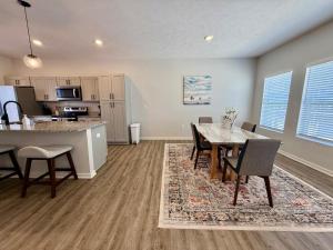 a dining room and kitchen with a table and chairs at The Meadowlark at Coventry Rows in Omaha +11 photos