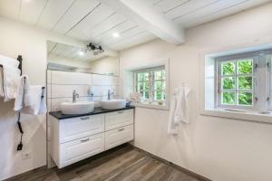 a white bathroom with two sinks and a mirror at Luis- Hus in Dagebüll +23 photos