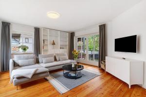 a living room with a couch and a tv at Moderner Schwarzwaldtraum in Oberharmersbach