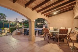 an outdoor patio with a table and chairs at Sa Caseta Rustic Villa in Cala d´Or