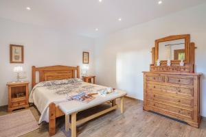 a bedroom with a bed and a dresser and a mirror at Sa Caseta Rustic Villa in Cala d´Or +22 photos