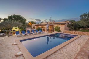 a swimming pool with chairs and a house at Sa Caseta Rustic Villa in Cala d´Or