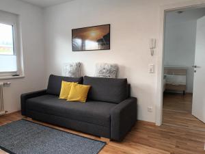 a living room with a couch with yellow pillows at Appartement Kärntner Seenland in Ledenitzen