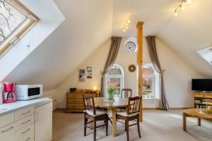a kitchen and dining room with a table and chairs at Gulfhof Oldersum Dachgeschoss in Moormerland