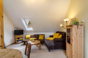 a living room with a couch and a table at Gulfhof Oldersum Dachgeschoss in Moormerland
