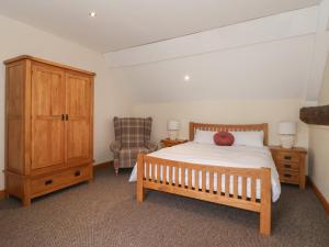 a bedroom with a bed and a cabinet and a chair at Mulberry Manor in Hull
