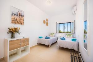 a bedroom with two beds and a dresser and a window at Finca Blanca in Calas de Mallorca +22 photos