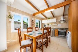 a kitchen and dining room with a wooden table and chairs at Finca Blanca in Calas de Mallorca