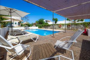a patio with chairs and a swimming pool at Finca Blanca in Calas de Mallorca