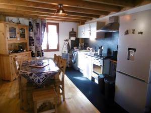a kitchen with a table and a kitchen with a stove at Logis Des Cerfs in Puyvalador