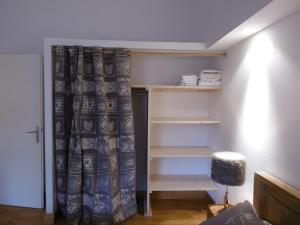 a room with a closet with a curtain and shelves at Logis Des Cerfs in Puyvalador