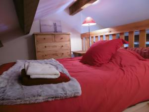 a bedroom with a red bed with a wooden headboard at Logis Des Cerfs in Puyvalador