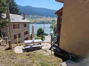 a bench sitting next to a building with a view of a lake at Logis Des Cerfs in Puyvalador