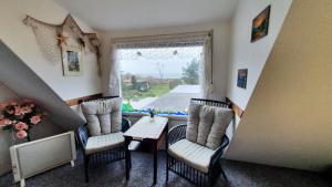 a room with chairs and a table and a window at Ferienwohnung Hiddenseeblick 1 in Dranske