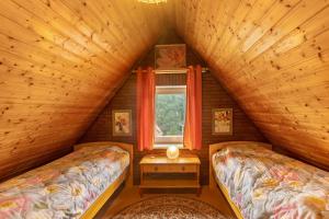 a attic bedroom with two beds and a window at Ferienwohnung Schloss-See-Bergblick in Waldeck