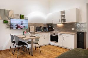 a kitchen with white cabinets and a table and chairs at Eichengeflüster Kranichzimmer in Wagenfeld +19 photos