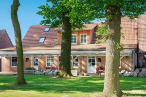 a house with trees in front of it at Eichengeflüster Kranichzimmer in Wagenfeld