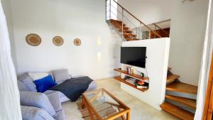 a living room with a couch and a staircase at Casa Lowen Villa with Private Pool in Las Terrenas