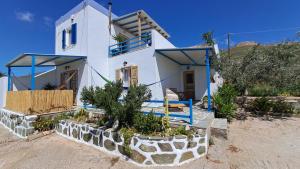 a white house with blue accents on the side of it at Syros Mandala Studios in Megas Gialos - Nites +33 photos