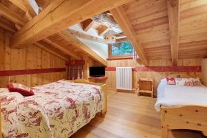 a bedroom with two beds in a wooden house at Maison Peroulaz Charvensod in Charvensod