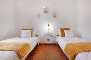 two beds in a room with white walls at Casa Tagaide in Tuineje