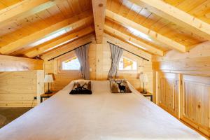 a bedroom in a log cabin with a large bed at Chalet Helnes - chalet contemporain in Saint-Oyen
