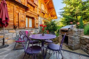 a patio with a table and chairs in front of a building at Chalet Helnes - chalet contemporain in Saint-Oyen