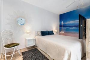 a white bedroom with a bed and a mirror at Pardelo in Los Menores