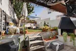 a patio with a chair and a table with plants at Pardelo in Los Menores