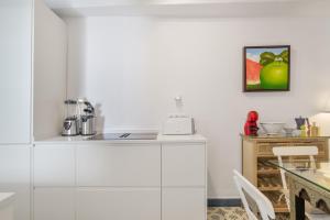 a kitchen with white cabinets and a table at Casa Castillo con Jardín in Vejer de la Frontera