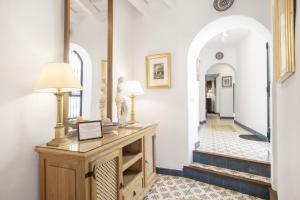 a hallway with a table and a mirror at Casa Castillo con Jardín in Vejer de la Frontera