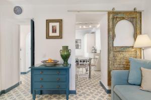 a living room with a blue dresser and a blue couch at Casa Castillo con Jardín in Vejer de la Frontera