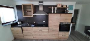 a kitchen with wooden cabinets and a stove at Ferienwohnung Küssaberg in Küssaberg