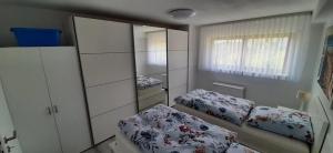 a bedroom with two beds and a mirror at Ferienwohnung Küssaberg in Küssaberg