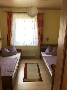 two beds in a room with a window at Ferienwohnung Strey in Rosenow