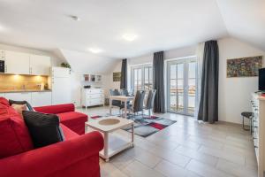 a living room with a red couch and a table at Appartement Irmi in Ihrlerstein