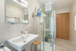 a white bathroom with a sink and a shower at Appartement Irmi in Ihrlerstein +18 photos