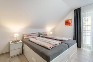 a bedroom with a large bed with a window at Appartement Irmi in Ihrlerstein