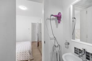 a bathroom with a pink blow dryer on the wall at Pensión las 3 Golondrinas in Santa Eularia des Riu +101 photos