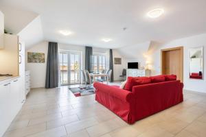 a living room with a red couch and a kitchen at Appartement Irmi in Ihrlerstein