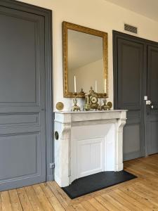 a mirror on top of a fireplace in a room at Château De Saint Mayeul in Joze +70 photos
