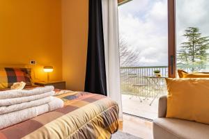 a bedroom with a bed and a sliding glass door at Al Castagneto Foresteria Lombarda in Montevecchia