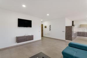 a living room with a couch and a tv on a wall at Edificio Bentejui 2 in Las Palmas de Gran Canaria
