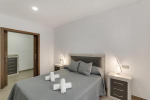 a bedroom with a bed with two candles on it at Edificio Bentejui 2 in Las Palmas de Gran Canaria