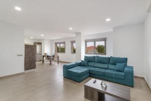 a living room with a blue couch and a table at Edificio Bentejui 2 in Las Palmas de Gran Canaria
