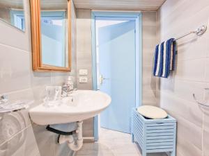 a white bathroom with a sink and a mirror at Loft Azzurro Old City Center in Rio Marina
