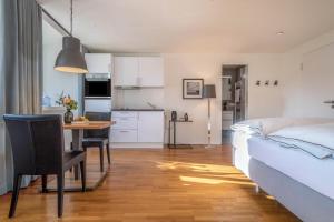 a bedroom with a bed and a table and a kitchen at 1 Zimmer-appartment Nr 14 in Wangen im Allgäu