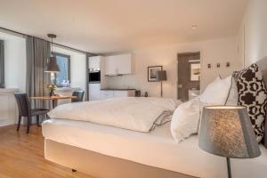 a bedroom with a large white bed and a kitchen at 1 Zimmer-appartment Nr 14 in Wangen im Allgäu