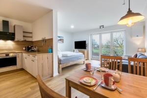 a kitchen and living room with a table and a dining room at Husbyries Wohnung 11 in Husby